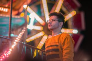 man in orange and black striped crew neck shirt wearing black framed eyeglasses